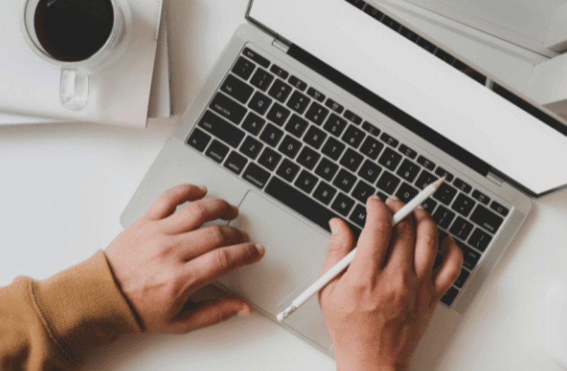 Hands typing on laptop, creating engaging website copy